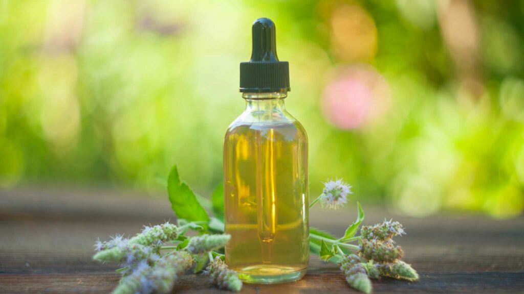 Image of a bottle of medicinal cannabis with some ornamental flowers placed around it