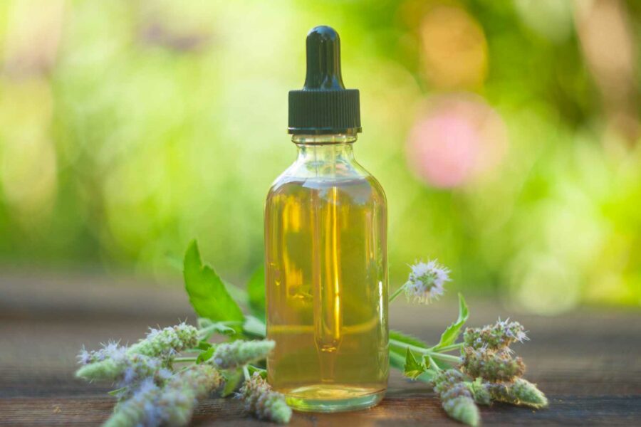 Image of a bottle of medicinal cannabis with some ornamental flowers placed around it